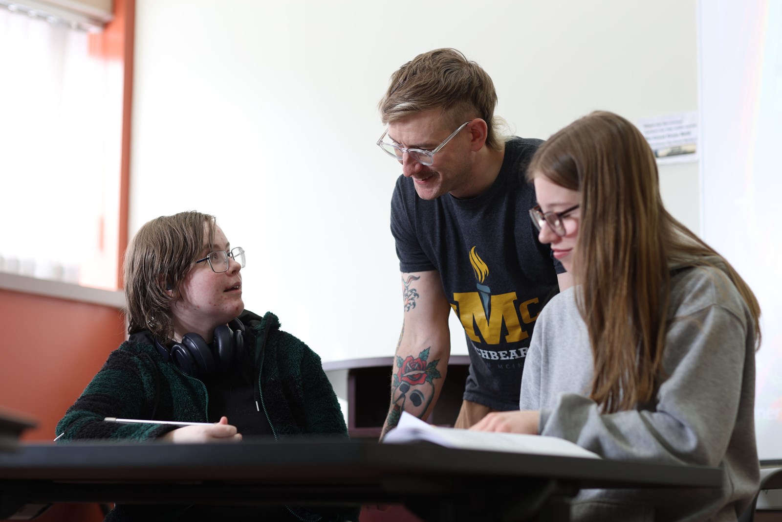 A student, parent, and teacher meeting together