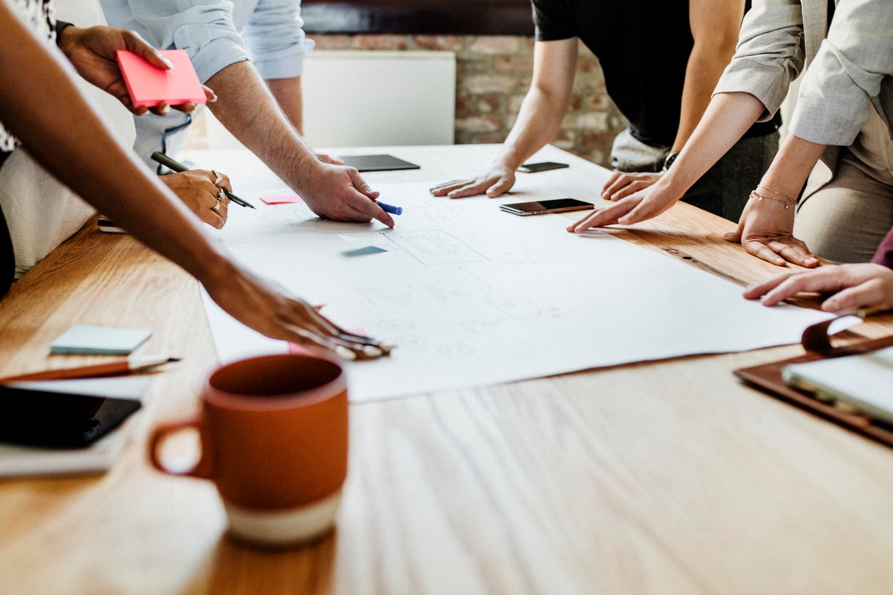 Hands on a desk, signifying working together