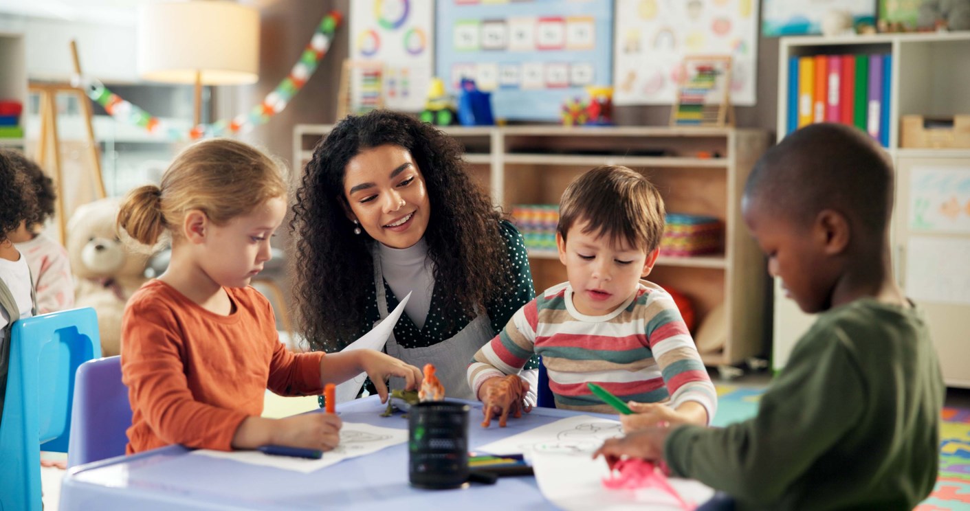 Teacher with young students at low table