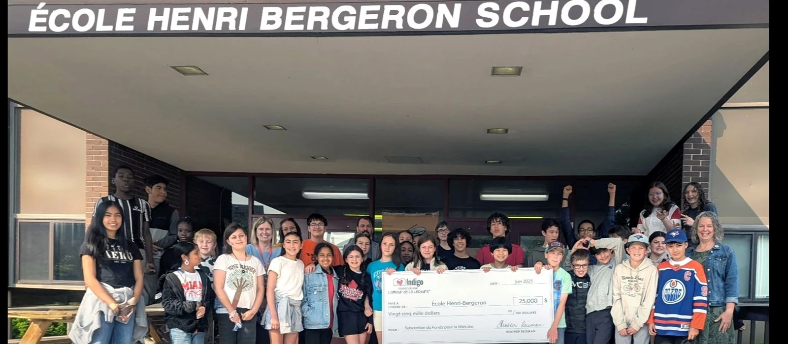École Henri-Bergeron staff and students in front of the school holding the big cheque from Indigo Love of Reading Foundation