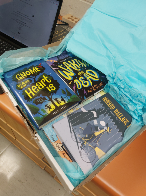A box of donated Casey Lyall books wrapped in blue tissue paper